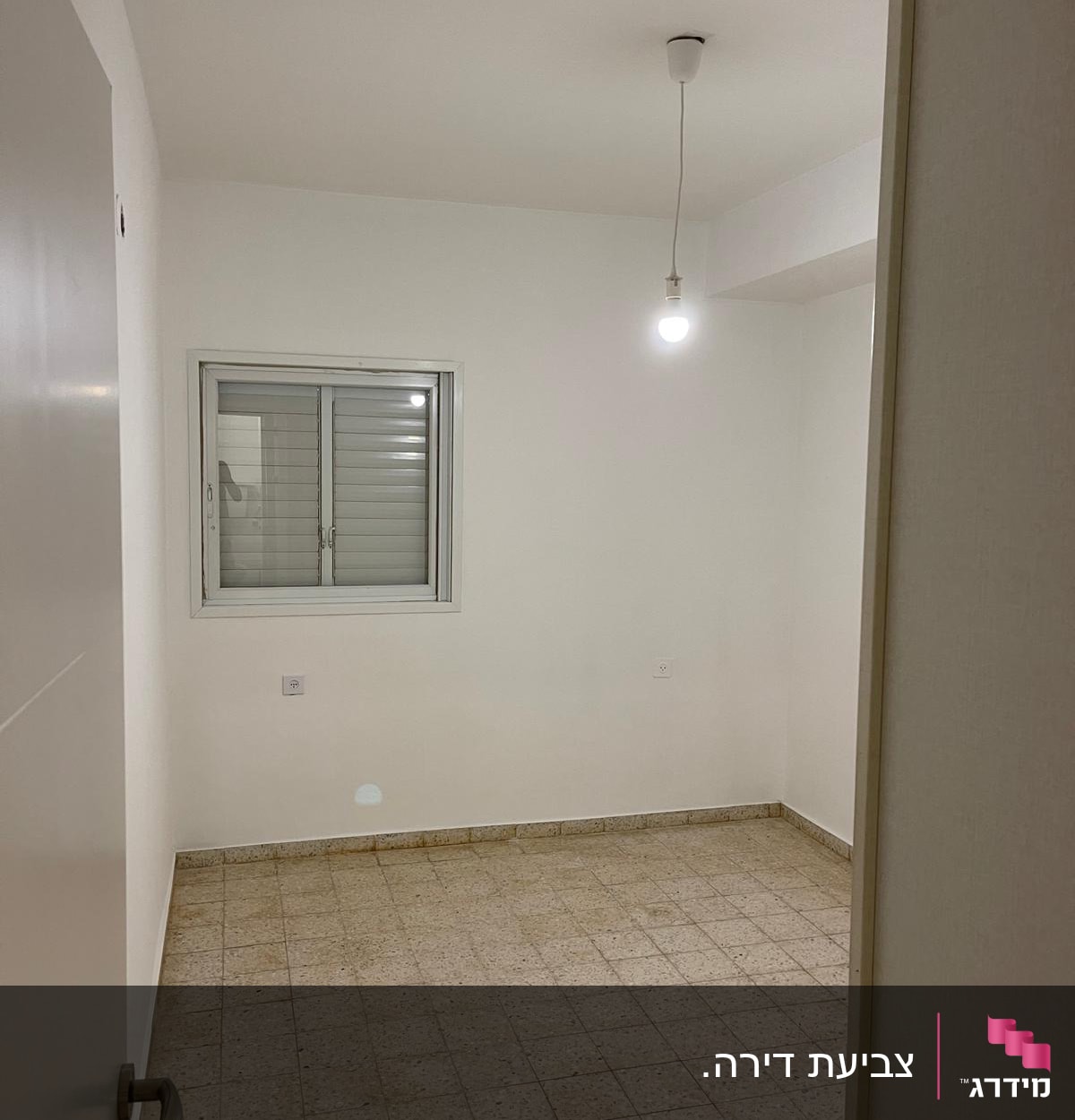 חדר ריק עם קיר צבוע בלבן ונורה תלויה